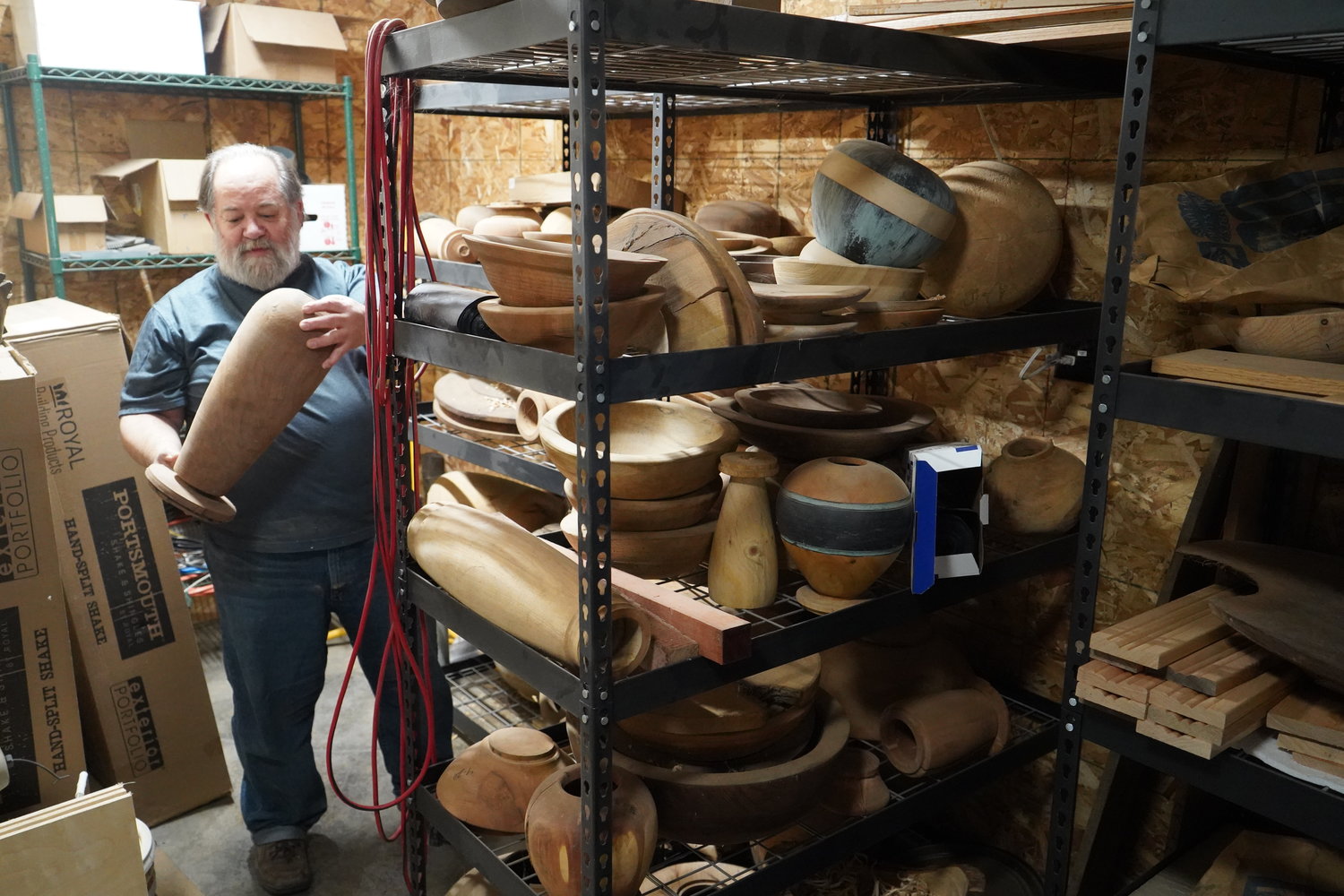 Fr. Means examines works in progress in his woodturning workshop.